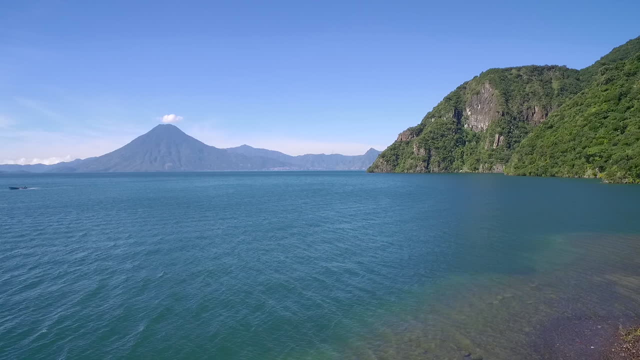 과테말라의 아마티틀란 호수 상공에서 멀리 파카야 화산이 보인다