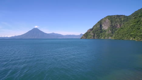 aerial over  lake amatitlan in guatemala reveals the pacaya volcano in the distance