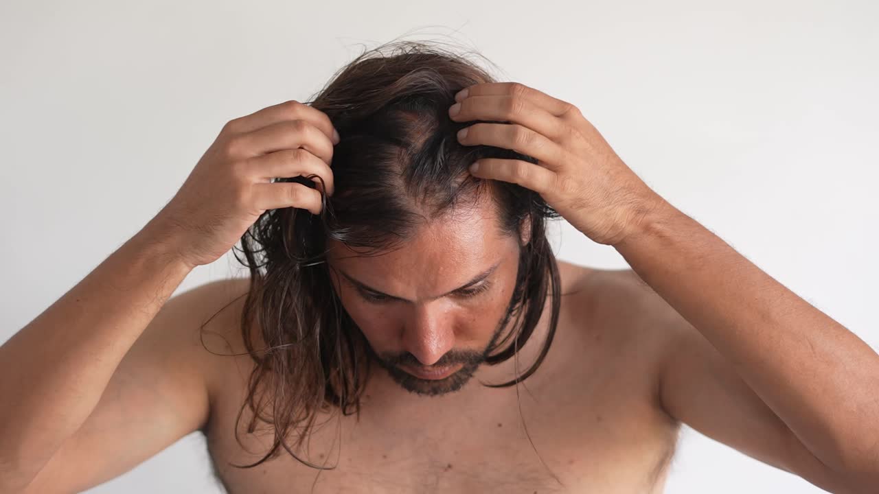 Man checking his hair for thinning or hair loss