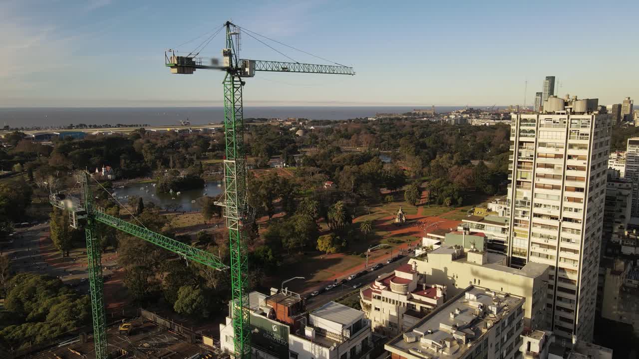 toma de órbita aérea de grúas en el sitio de construcción en buenos aires durante la puesta de sol