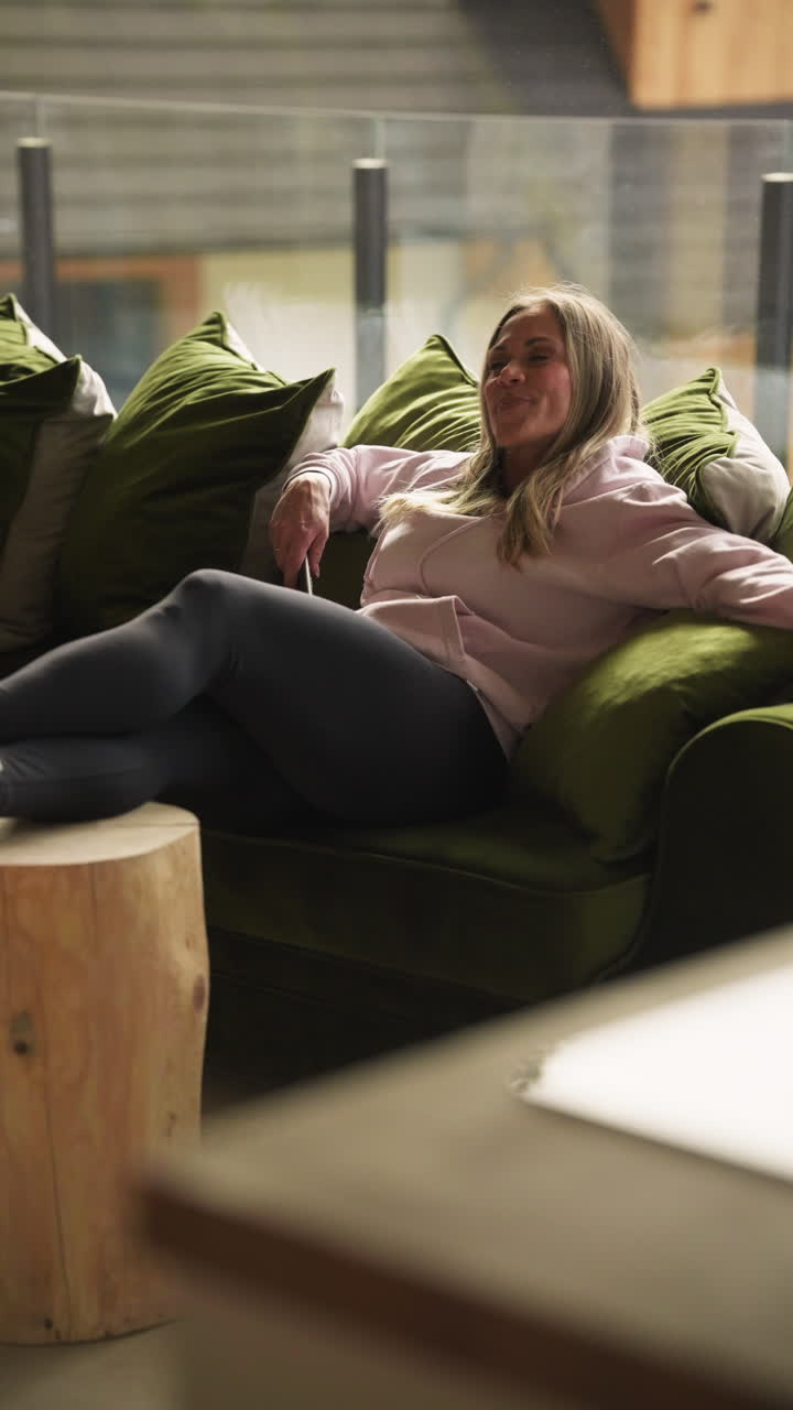 Donna che si gode il relax su un divano in un hotel a Jaszczurówka, Zakopane, Polonia - Ripresa verticale