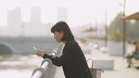 asian businesswoman using smartphone outdoors