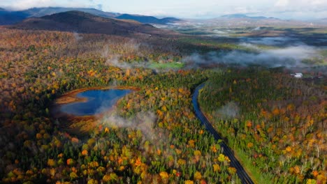 Drone-footage-of-a-lake-surrounded-with-peak-fall-foliage-and-cloud-inversion-in-Upstate-New-York