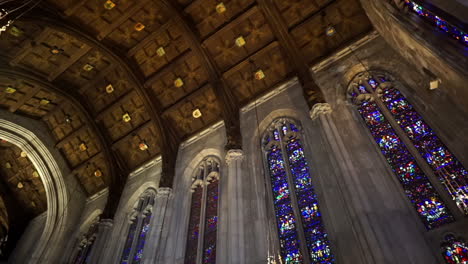 pan of cathedral ceiling with stained glass windows and wooden ceiling panels