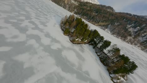 vuelo a través de un lago congelado entre altas montañas
