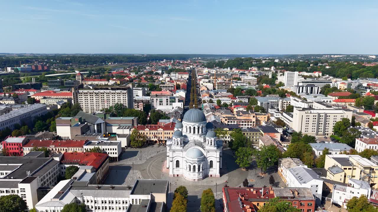 Aerial panoramic view of central Kaunas, Lithuania, featuring the prominent St. Michael the Archangel Church and the long pedestrian Laisvės Alėja stretching into the distance