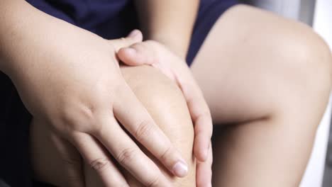 hand on the knee with massage who has been suffering from persistent pain swell