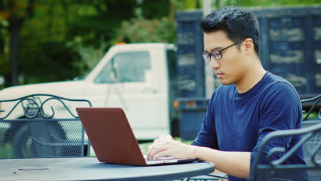 Un-Joven-Asiático-Trabaja-Con-Una-Computadora-Portátil-1