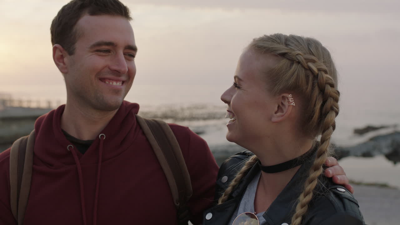 해변 해변에서 채팅하는 젊은 행복한 커플의 초상화