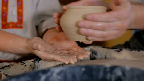 potter showing how to work with ceramic in pottery studio