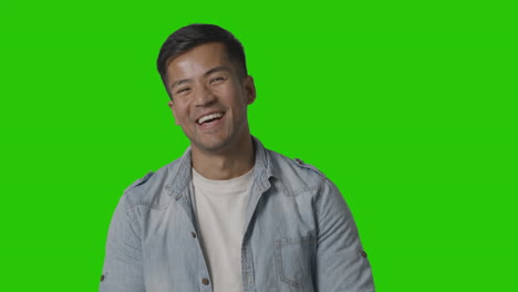 portrait of casually dressed smiling young man against green screen 1