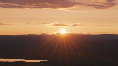 The-bright-midnight-sun-passes-on-the-horizon,-casting-a-warm-light-over-the-landscape