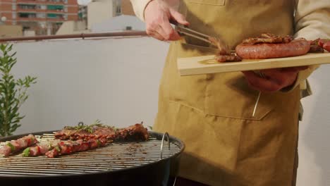 man grilling meat on rooftop barbecue