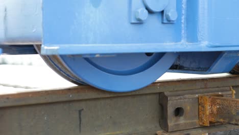 vista de cerca de las ruedas industriales azules en una vía ferroviaria