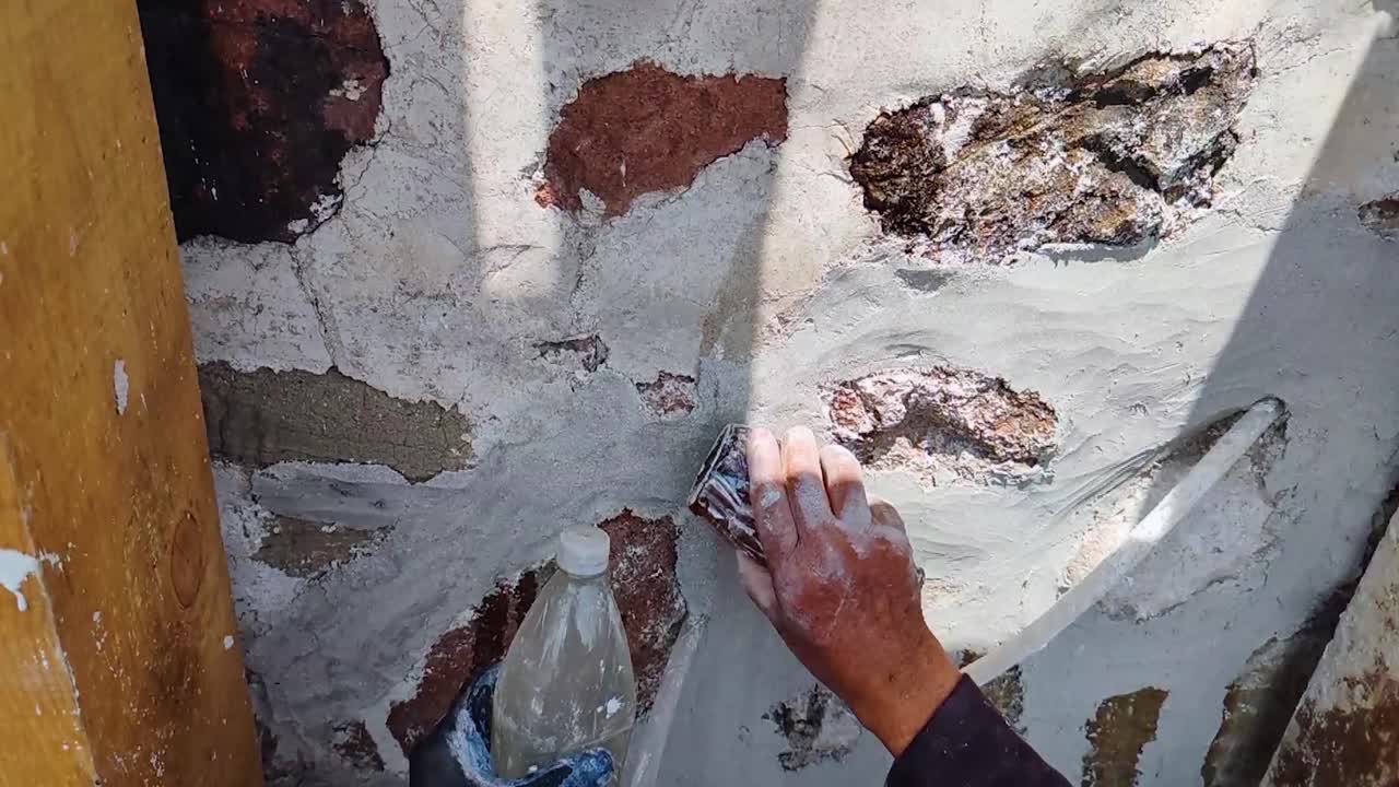 Detail of the polishing process of lime and sand mortar, hydrated with natural mucilage, during the creation of a burnished finish applied to an intervened rock masonry wall in Tepotzotlán, Mx