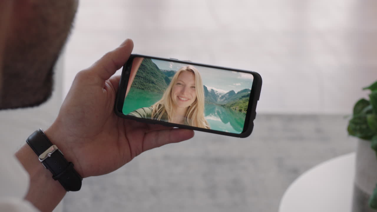 hombre joven chateando en video con su novia en el teléfono inteligente saludando con la mano mujer joven compartiendo vacaciones viaje pareja teniendo una relación a larga distancia