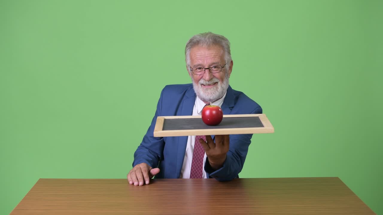 hombre de negocios barbudo y guapo contra un fondo verde.