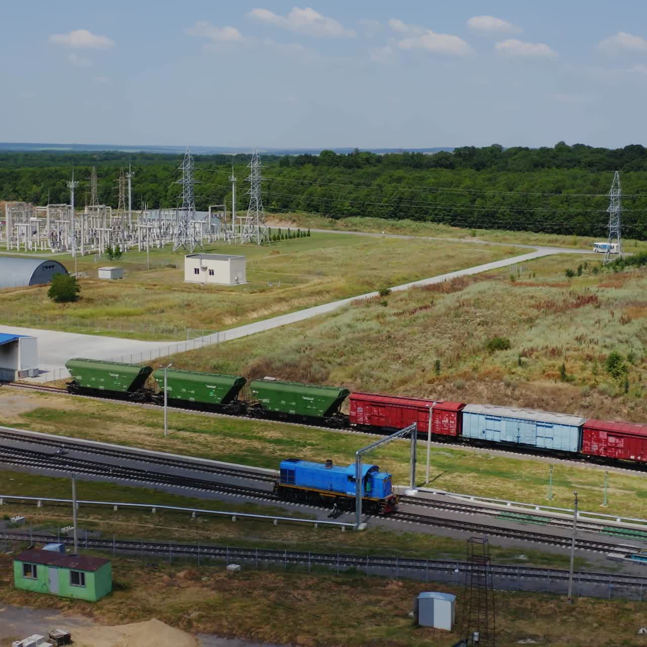 Cargo wagon moving alone. Freight train traveling to the modern plant for grain storage. Railroad with freight carriages on industrial zone background.