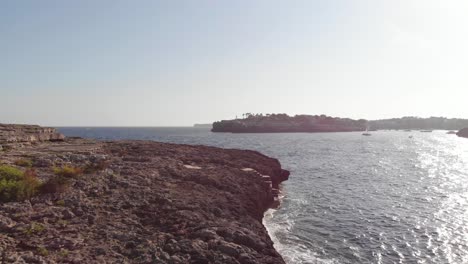 AERIAL:-Flying-under-tree-but-over-fissured-sea-cliffs-of-spanish-coast