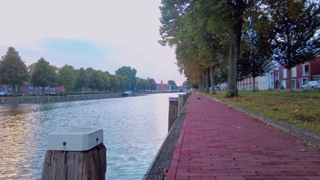 pan de ángulo bajo sobre la orilla del agua del muelle y el pavimento en la hora azul en s hertogenbosch