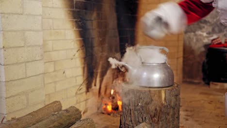 boiling retro aluminium kettle. teapot steams. santa claus takes a boiling kettle. closeup. teapot on a log.