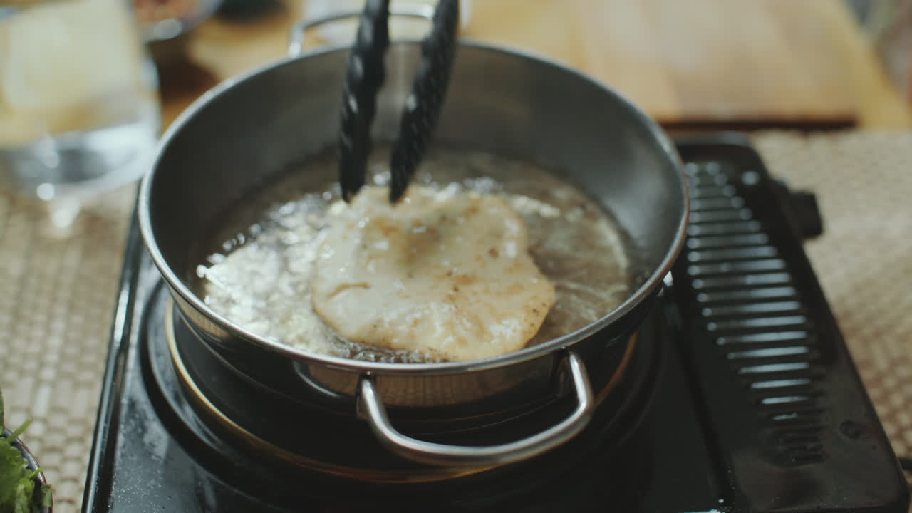 에서 뜨거운 기름으로 인도 플래트브레드를 조리하는 클로즈업