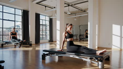 women practicing pilates on reformers in a studio