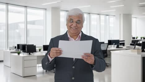 el gerente senior indio feliz leyendo informes