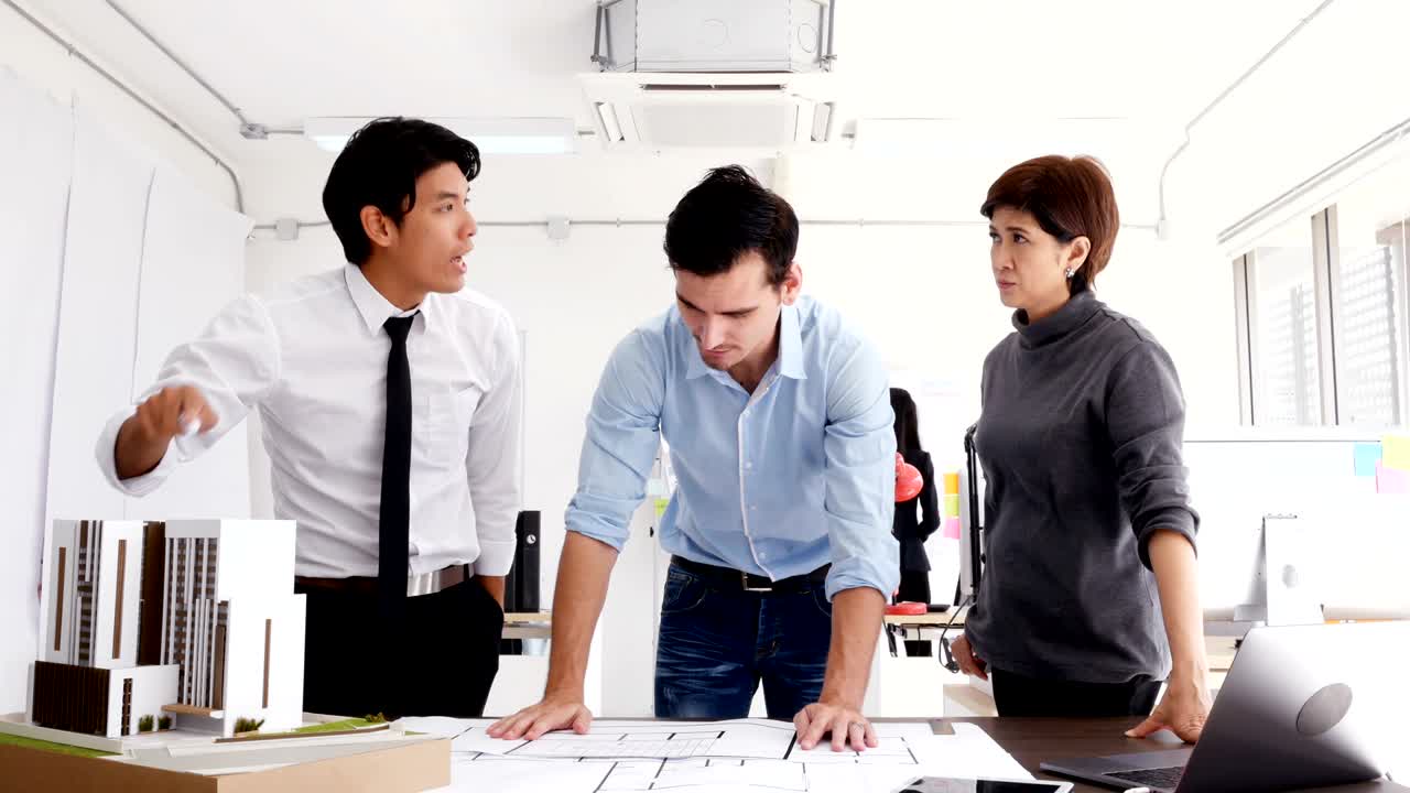 사람들은 건축 프로젝트에 대해 논의하고 서로 의견이 분분합니다. 진지한 감정으로 일하는 사람들이죠.