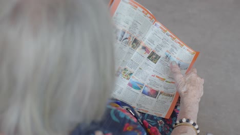 Zeitlupe-Zeigt-Eine-Aufschlussreiche-Aufnahme-Einer-älteren-Frau,-Die-In-Einer-Zeitschrift-Umblättert