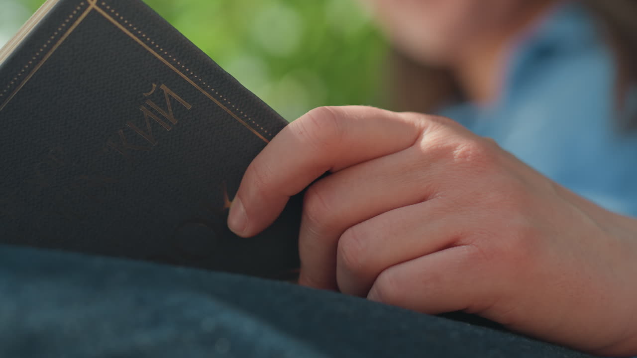 편안하게 책을 들고 평화롭게 앉아 있는 백인 여성, 닫힌 책을 무릎에 올려놓은 채 조용히 휴식을 취하는 차분한 여성, 차분하게 앉아서 책을 읽는 밝은 피부의 평온한 여성