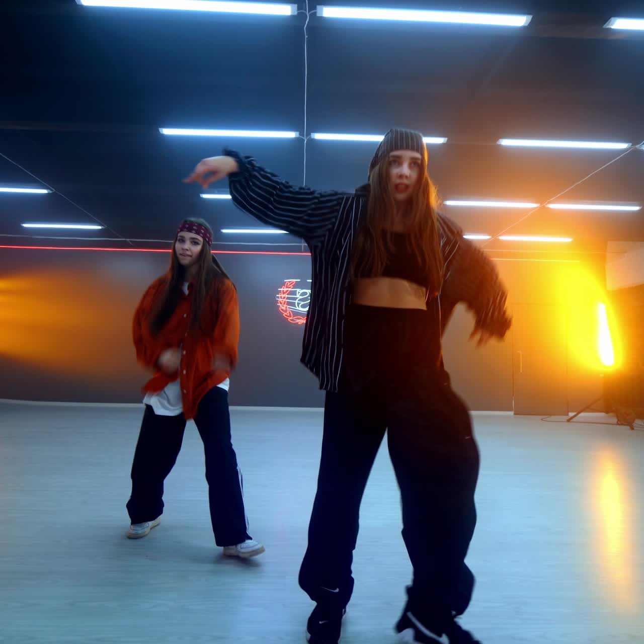 Hip hop dance style performed in modern studio. Girls trio moving energetically in the spacious room