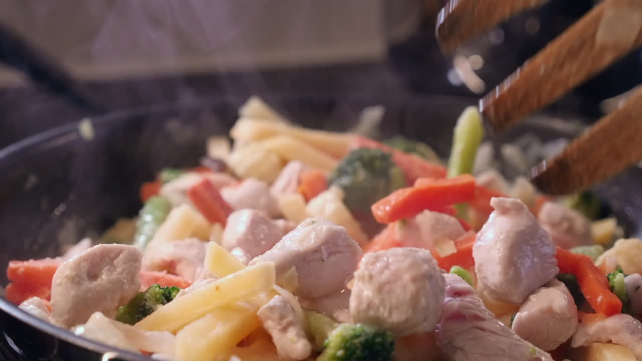 목조 포크 는  과 채소 를 주방 소스 팬 에 어 는다