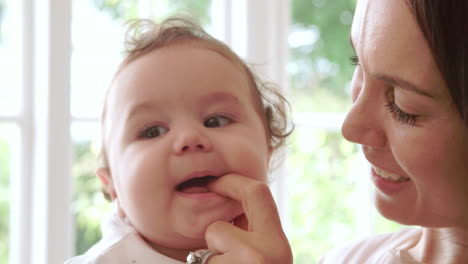 teething baby boy biting mother's finger