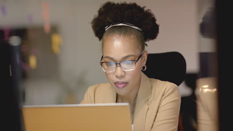 focused young african american woman works diligently on her business laptop in an office setting