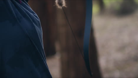 Archery-girl-loads-her-bow-in-a-forest-and-shoots-close-shot