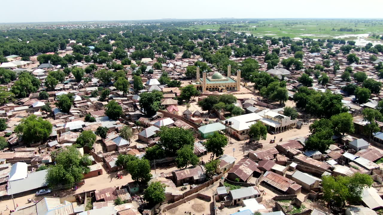 A shanty town suburb of Argungu in Kebbi State, Nigeria and the National Mosque - ascending aerial view