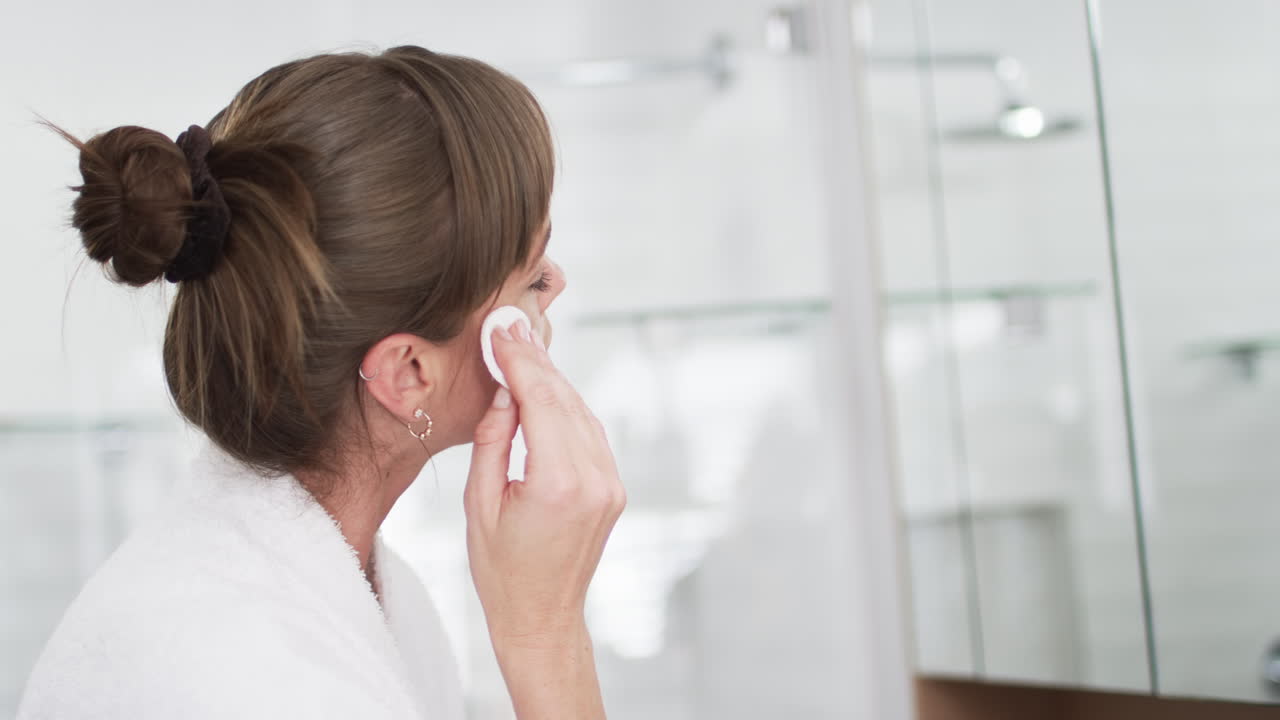 Middle-aged Caucasian woman in a bathroom, with copy space