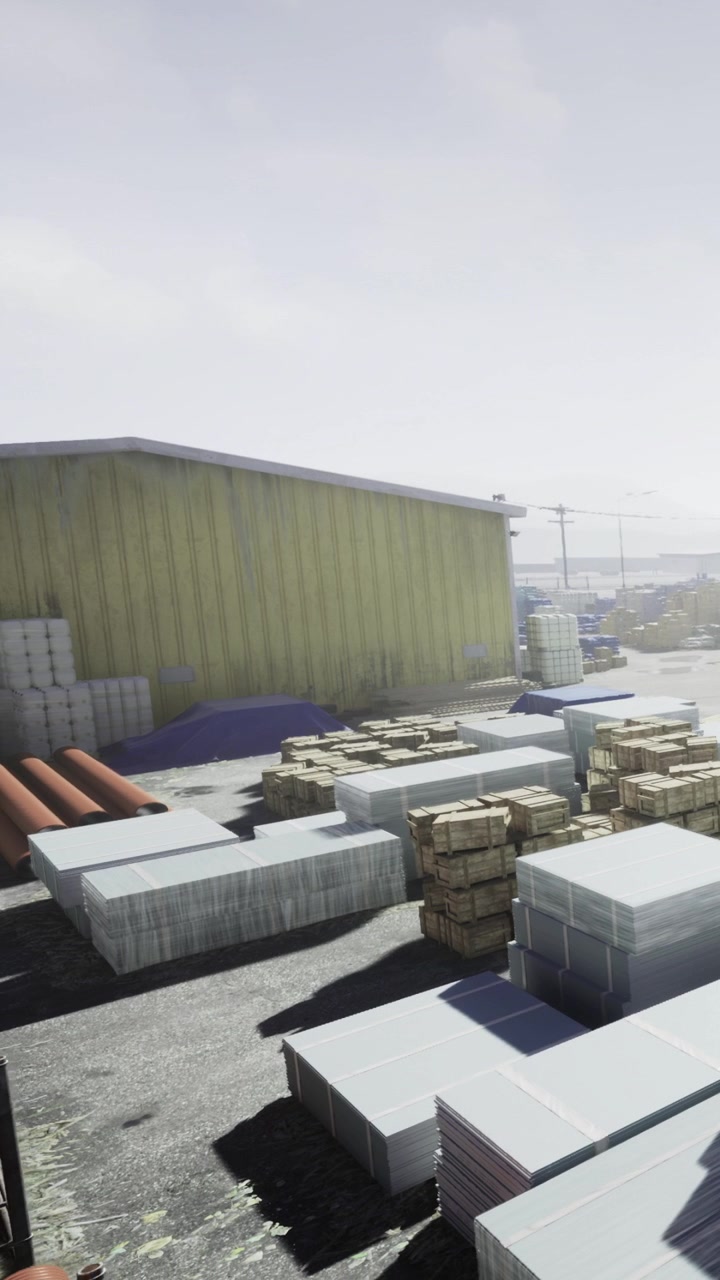 Construction site with materials and storage near warehouse in daylight hours