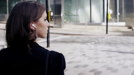 attractive business woman commuter using smartphone walking in city of london