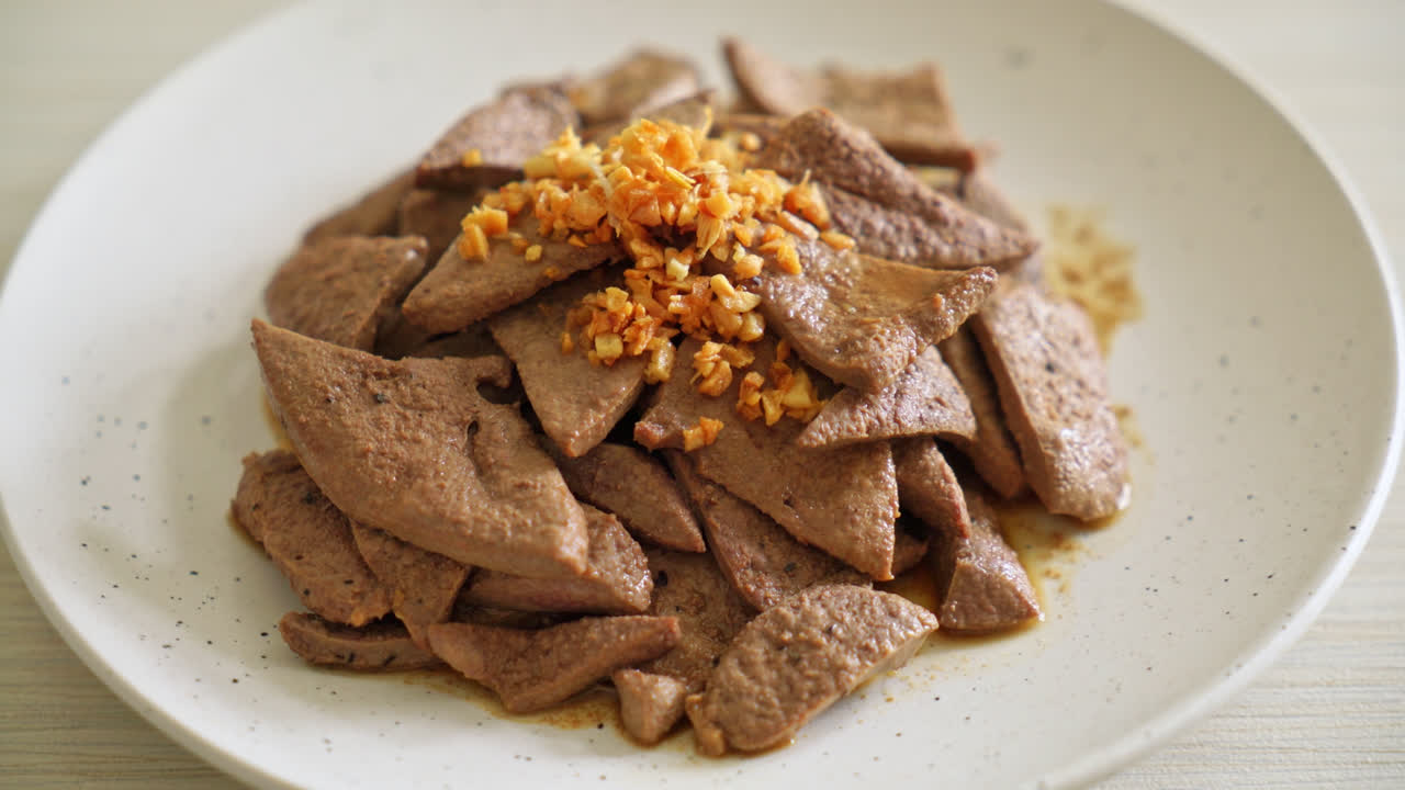 접시에 마늘을 곁들인 집에서 볶은 돼지 간