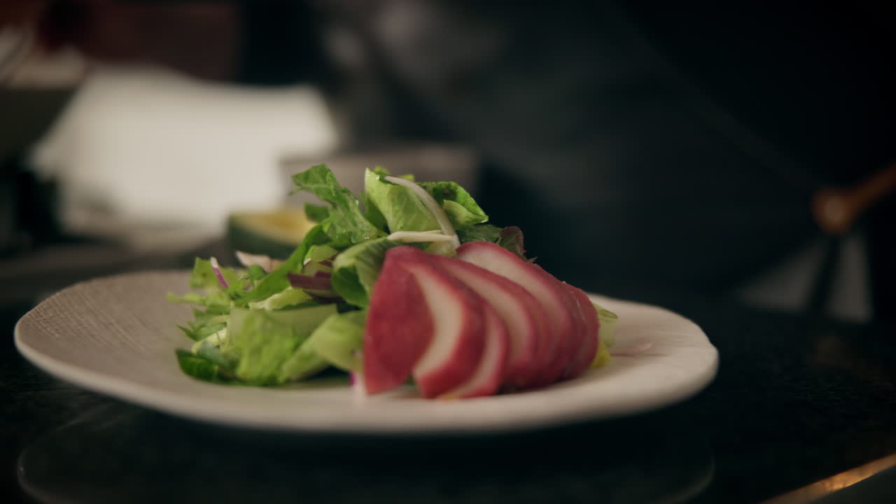 요리사 가 진주 와 혼합 된 초록색 러드 를 준비 하고 있다