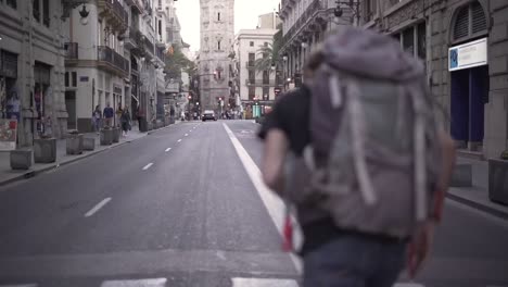man with a backpack walking down a city street