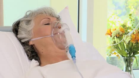 woman lying on the bed with an oxygen mask