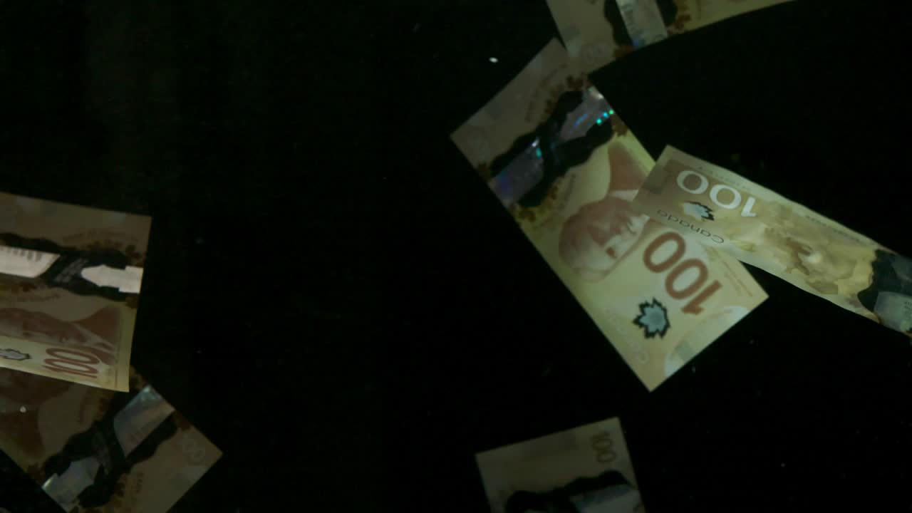 падающие летящие банкноты американского канадского доллара на черном фоне в 4k loopable. высококачественные падающие банкноты доллара в 4k. видео loopable