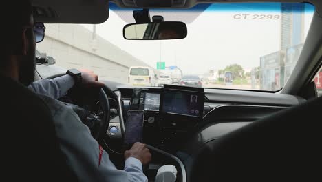 driver navigating dubai roads in a taxi