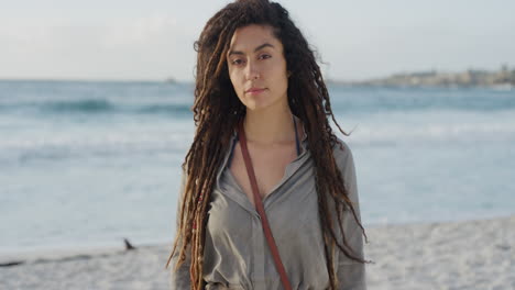 Retrato-De-Una-Hermosa-Mujer-De-Raza-Mixta-En-La-Playa-Que-Parece-Tranquila-Y-Disfruta-Del-Pacífico-Océano-Junto-Al-Mar,-Peinado-De-Rastas-Femenino-Independiente