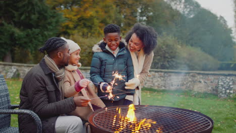 Family-having-fun-with-sparklers-in-autumn-garden-at-home---shot-in-slow-motion