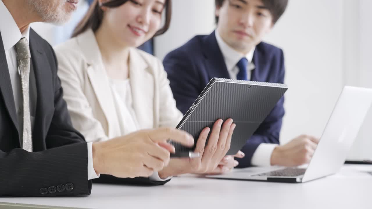 아시아 사업가 한 명이 회의에서 설명하고 있다.