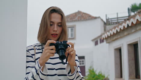 ragazza che scatta foto con la vecchia telecamera in case bianche. bellissimo viaggio turistico